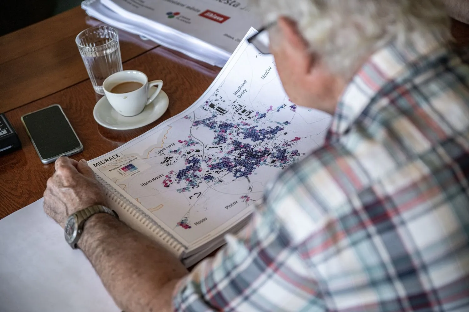 A reader leafing through a printed report with a hexagon grid map